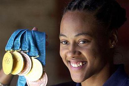 Marion Jones, sonriente con las cinco medallas, tres de oro y dos de bronce, ganadas en Sidney.