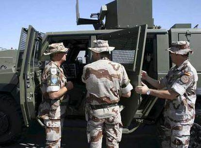 Tres mandos militares revisan un vehículo blindado en la base española de Herat en septiembre de 2008.