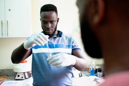 Brian Gitta, uno de los laureados de los Premios Rolex a la iniciativa 2019, realiza un análisis de malaria. (Foto: ©Rolex/ Joan Bardeletti).