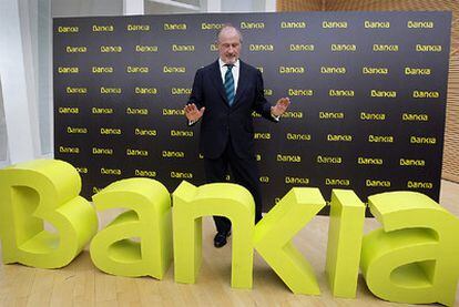 Rodrigo Rato, presidente de Bankia, junto al logo de la entidad.