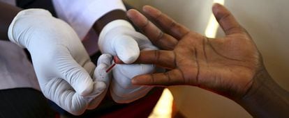Un médico toma una muestra de sangre a un hombre en Kampala (Uganda) para hacerle la prueba del VIH.