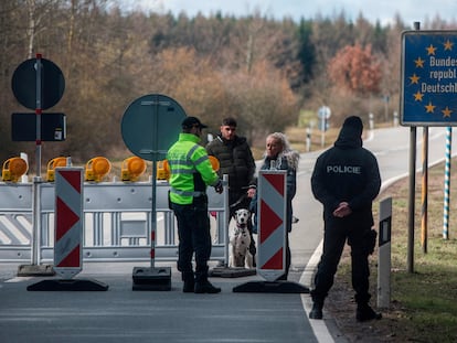 Un policía habla con una pareja ayer en la frontera entre Alemania y la República Checa.