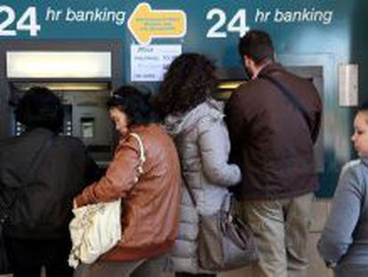 Ciudadanos chipriotas sacan dinero de un cajero autom&aacute;tico este fin de semana.