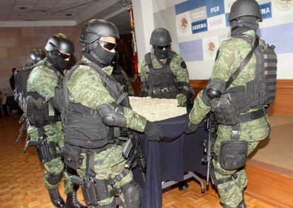 Militares transportan paquetes de billetes decomisados al cartel de Sinaloa.