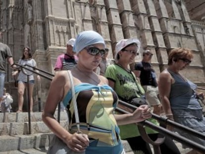 Varios turistas extranjeros visitan la catedral de Palma de Mallorca.