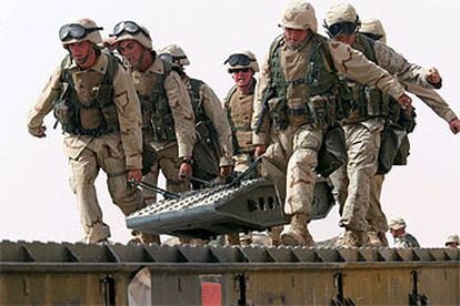 <i>Marines</i> del 8º Batallón de Apoyo de Ingerniería trasladan una pieza de construcción en un campamento al norte de Kuwait.