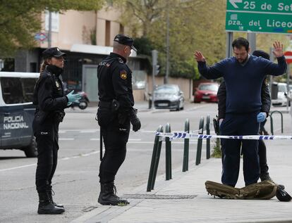 Varios miembros de la Policía Nacional cachean a una persona durante el confinamiento por la pandemia de coronavirus en Madrid.