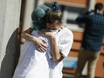Dos sanitarias se abrazan durante una pausa en el exterior de Urgencias del hospital Severo Ochoa de Leganés (Madrid). / L. SEVILLANO