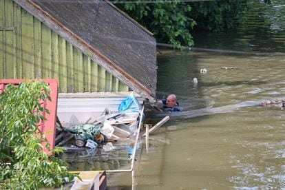 Un vecino de Jersón nada junto a una casa en un área inundada de la ciudad ucrania, el miércoles.