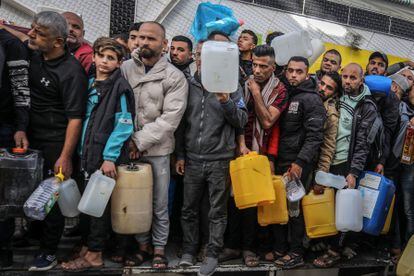 Palestinos esperan para rellenar sus bidones en una gasolinera en Gaza, este domingo.