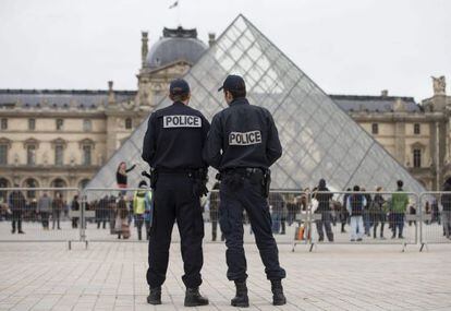 Dos polic&iacute;as franceses observan los alrededores del Museo del Louvre.