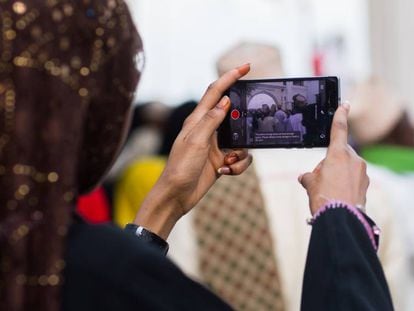 Una mujer hace fotograf&iacute;as con su &#039;smartphone&#039; durante las fiestas Maulidi en Kenia.   
