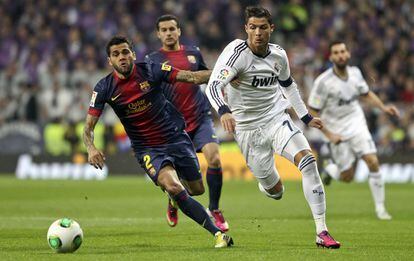 Dani Alves trata de atrapar el balón ante Ronaldo.