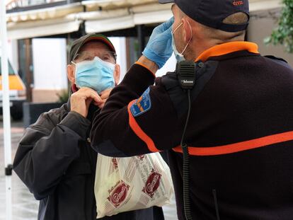 Un policía local explica a un ciudadano cómo colocarse la mascarilla como protección frente a la covid-19 en Palma de Mallorca.