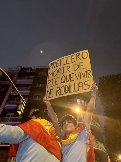 Un manifestante en la calle de Ferraz sostiene un cartel de "prefiero morir de pie que vivir de rodillas", en una imagen que circula en redes.