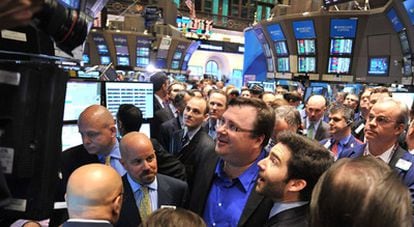 El consejero delegado de LinkedIn, Jeff Weinner, y el fundador del portal, Reid Garrett Hoffman, con gafas y camisa azul, siguen la evolución de las acciones en Wall Street el primer día de su cotización en bolsa.