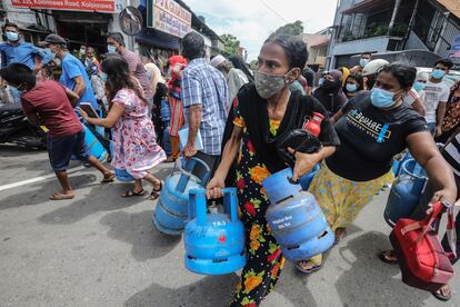 Un grupo de personas bloquea una carretera en Colombo, capital de Sri Lanka, en una protesta por la carestía de bombonas de gas, este sábado.