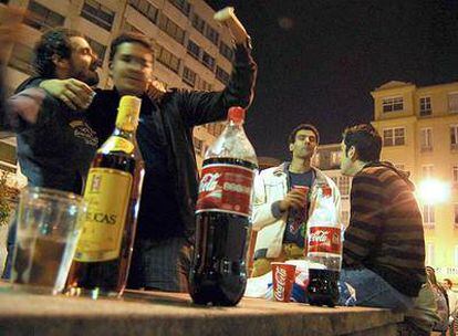 Varios jóvenes hacen <i>botellón</i> en la plaza del Humor, en A Coruña.