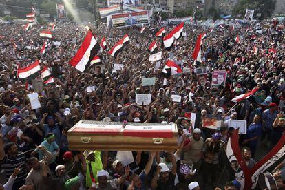 Numerosos simpatizantes del depuesto presidente Mohamed Mursi portan un féretro simbólico en una protesta en la que participaron cientos de manifestantes, a las puertas de la mezquita de Rabaa al Adauiya en El Cairo, 9 de julio de 2013. Los seguidores de Mursi vuelven a salir a las calles tras la muerte ayer de al menos 51 personas, en su mayoría islamistas, ante la sede de la Guardia Republicana en El Cairo.