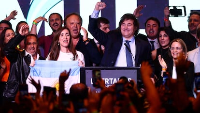 Victoria Villarruel, con una bandera argentina, y Javier Meloni celebran los resultados de las elecciones presidenciales en su país.