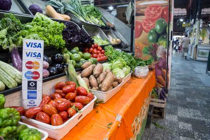 Un puesto de verduras oferta sus productos a pago con tarjeta en el mercado El Progreso de Buenos Aires, Argentina. 
