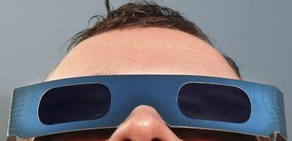 Un óptico se prueba un par de gafas especiales para contemplar eclipses solares en su tienda situada en Rostock (Alemania). Efe