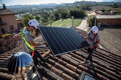 Unos operarios instalan unas placas solares en una casa de Barcelona.
