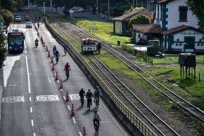 Unas personas montando en bicicleta al lado de una vía ferroviaria en Bogotá  