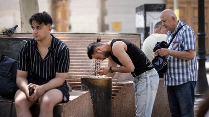 Un turista se refresca en la Rambla de Barcelona, este martes.