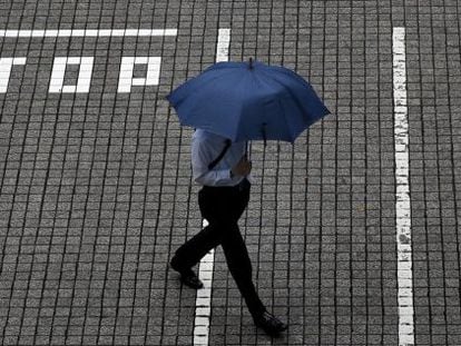 Un hombre pasea por los aleda&ntilde;os de la Bolsa de Tokio