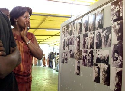 Una mujer observa, el 29 de septiembre de 2002, tres días después del accidente del Joola, fotos de cadáveres encontrados.
