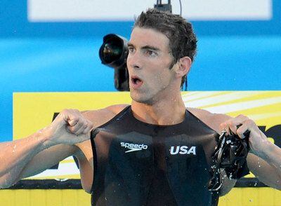 Michael Phelps enseña la marca de su patrocinador, Speedo, tras ganar la final.