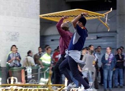 Dos jóvenes radicales se disponen a lanzar una valla en 2002 junto al estadio Bernabéu.