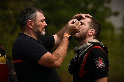 Un bombero atiende a un colega con gotas para los ojos, cerca de Saint-Magne, este jueves.