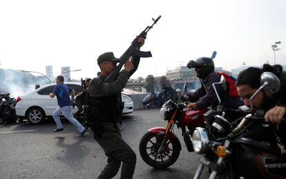 Soldados y civiles reaccionan al sonido de los disparos cerca de la base aérea La Carlota en Caracas (Venezuela).