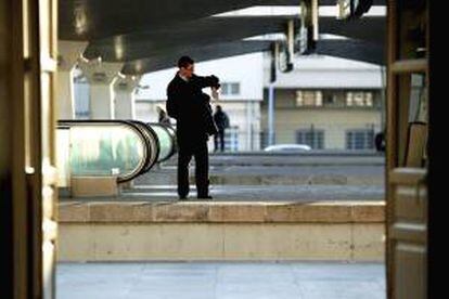 Un viajero comprueba la hora en su reloj de muñeca mientars espera en un andén de la estación de trenes de Canpanha en Oporto (Portugal). EFE/Archivo