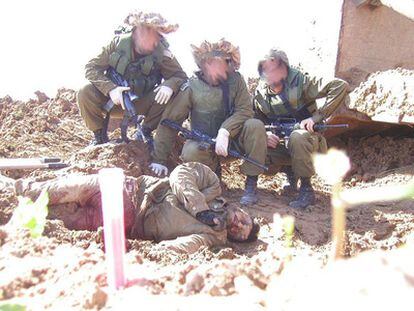 Soldados israelíes posan con el cadáver de un palestino.