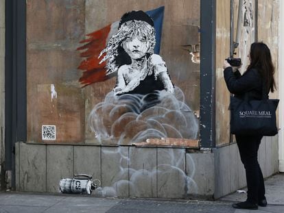 Una mujer observa el grafiti de Banksy que apareci&oacute; en enero frente a la embajada francesa en Londres. 