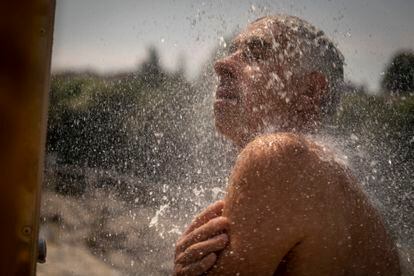 Un hombre se refresca en una ducha en las termas de A Chavasqueira, el martes en Ourense. La ola de calor alcanza su “culmen” con avisos rojos en Andalucía y Extremadura por temperaturas de 44°, en concreto en la campiña sevillana y en las Vegas del Guadiana.