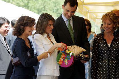 Los príncipes de Asturias hojean un libro infantil en presencia de Carmen Calvo (a la izquierda) y Esperanza Aguirre.