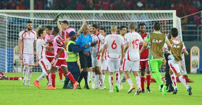 El &aacute;rbitro Rajindraparsad Seechurn se aleja del terreno de juego increpado por los jugadores tunecinos.