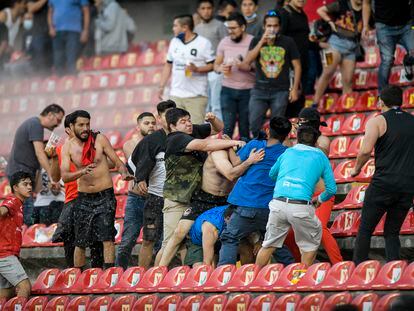 Hinchas de los Gallos de Querétaro y del Atlas se enfrentan en las gradas del estadio Corregidora, este sábado.