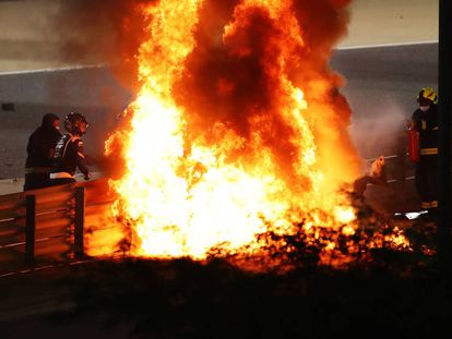 Operarios intentan apagar el incendio del coche de Grosjean.