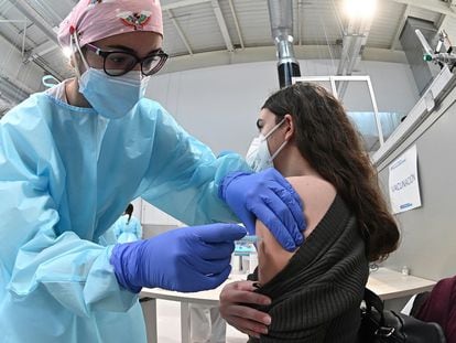 Una sanitaria pone la vacuna contra la covid-19 a una mujer durante el inicio del proceso de vacunación en el hospital Enfermera Isabel Zendal.