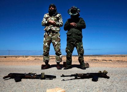 Rebeldes antigubernamentales rezan en la carretera mientras se preparan para luchar contra las fuerzas  de Gadafi cerca de Bin Yawad.