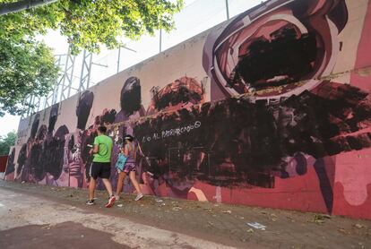 Un hombre y una mujer pasan este lunes por delante del mural vandalizado.