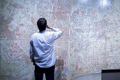 Un joven ante un plano del Eixample en la exhibición <i>Cerdà y la Barcelona del futuro</i>, que expuso el CCCB.