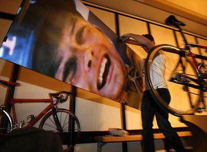 Un operario retira un panel con la foto de Jan Ullrich en el podio del Tour de 1997 después de la conferencia de prensa del alemán en Hamburgo.