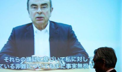 Junichiro Hinonaka, abogado defensor Carlos Ghosn (en la pantalla), asiste a la reproducción de un video grabado por su defendido.