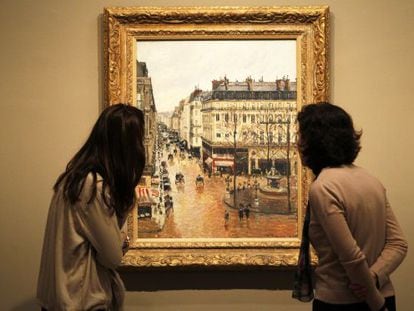 Dos visitantes contemplan el cuadro 'Rue Saint-Honoré por la tarde. Efecto de lluvia', de Camille Pissarro, en el Museo Thyssen.